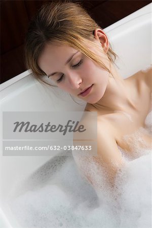 Femme se détendre dans le bain à bulles