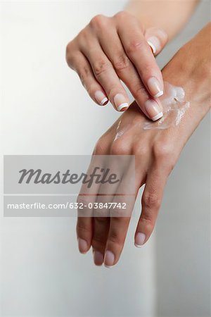 Woman moisturizing hands, cropped