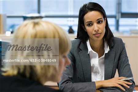 Female executive listening to colleague talk