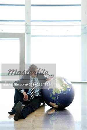 Homme assis à côté de la balle dans le hall
