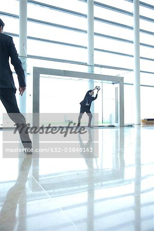 Businessmen playing soccer in lobby