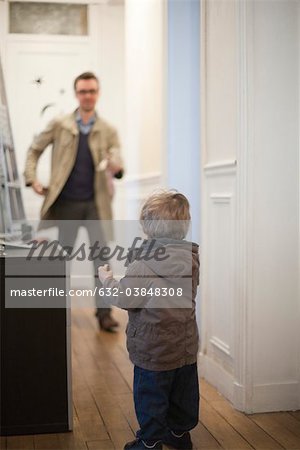 Father and toddler son preparing to leave house
