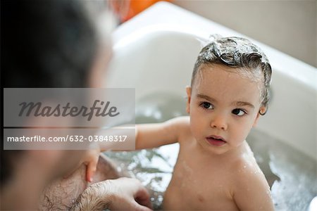 Garçon enfant en bas âge, prendre un bain avec son père