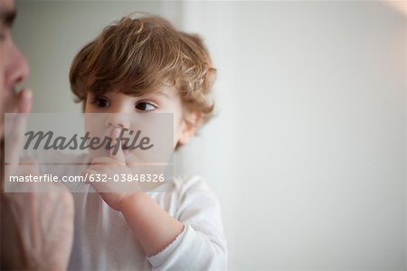 Father hushing toddler boy