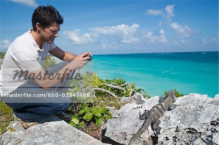 Man Taking Picture of Iguana, Reef Playacar Resort and Spa, Playa del Carmen, Mexico