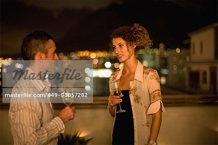 Couple having wine on terrace at night