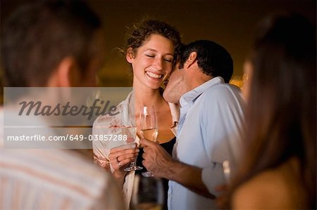 Couple kissing at party at night