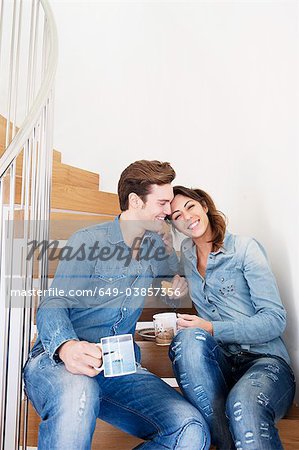 Couple drinking coffee on stairs