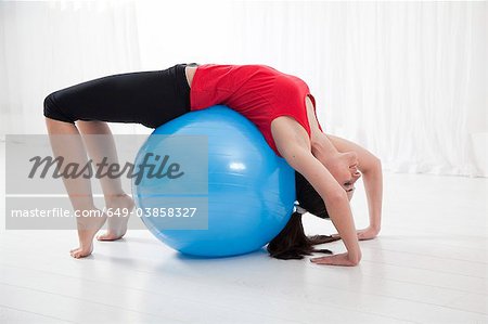 Femme qui s'étend sur ballon d'exercice