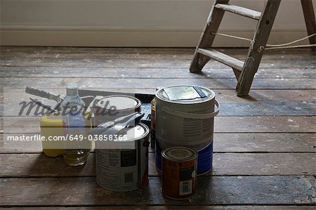 Paint cans and brushes in empty house