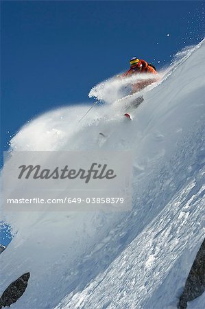 Skier turning on steep mountain face