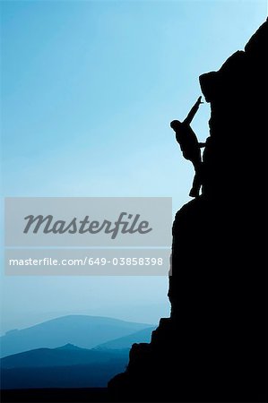 Man climbing up rocky hillside