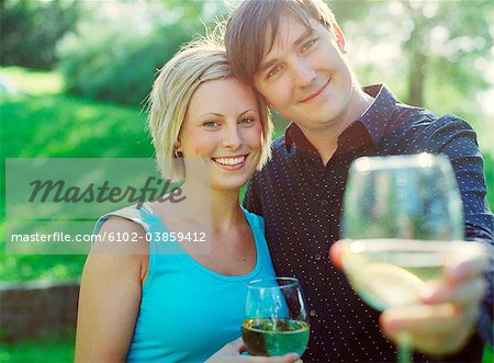 Portrait of couple holding glasses of wine, smiling