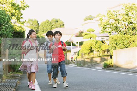 Enfants avec cartable marchant dans la rue