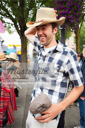 Man Trying on Hat at Market