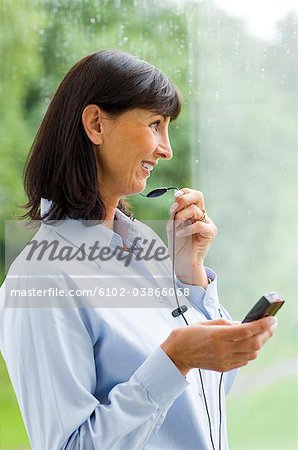 Eine Frau mit einem Headset und ihr Handy, Schweden.
