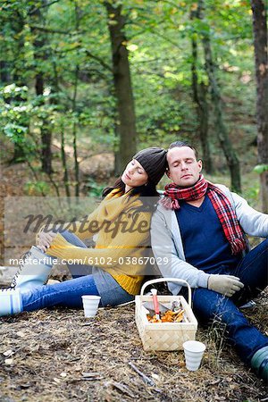 Un homme et une femme, cueillette de champignons dans la forêt, Suède.