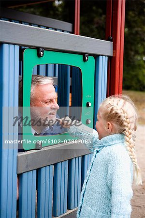 Grand-père et un petit-enfant jouant ensemble sur un terrain de jeu, Suède.