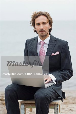 Un homme avec un ordinateur sur la plage, Suède.