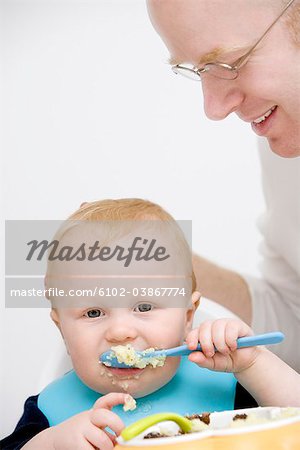 Un père regarde son fils mange, Suède.