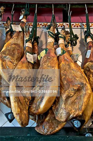 Espagnoles jambons suspendus dans une restaurant bodega, Séville, Andalousie, Espagne, Europe