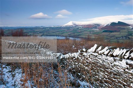 Snow dusted dry stone wall on the Allt yr Esgair looking towards Llangorse Lake and the Black Mountains, Brecon Beacons National Park, Powys, Wales, United Kingdom, Europe