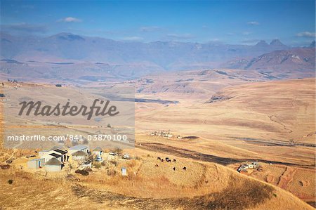 Dorf am Hang mit Cathedral Peak Nature Reserve im Hintergrund, Ukhahlamba-Drakensberg Park, UNESCO Weltkulturerbe, KwaZulu-Natal, Südafrika, Afrika