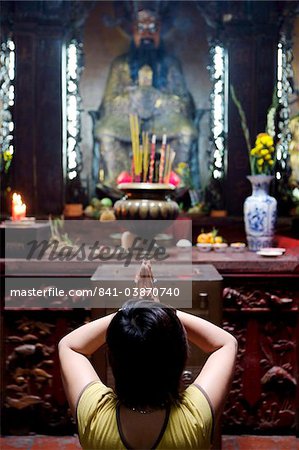 Habitante prier et méditer devant des offrandes au temple bouddhiste, Ho Chi Min-ville, Vietnam, Indochine, Asie du sud-est, Asie &#10;