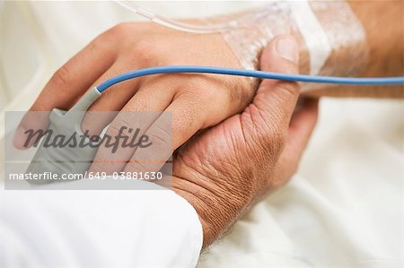 Personne tenant la main du patient de l'hôpital