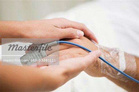 Personne tenant la main du patient de l'hôpital