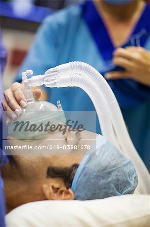 Nurse giving anesthetic gas to patient