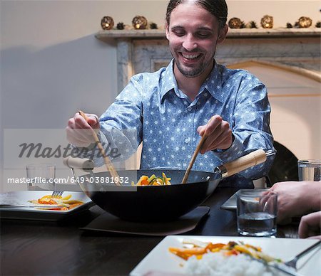 Man serving dinner from wok