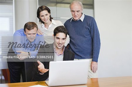 Business people using laptop in office