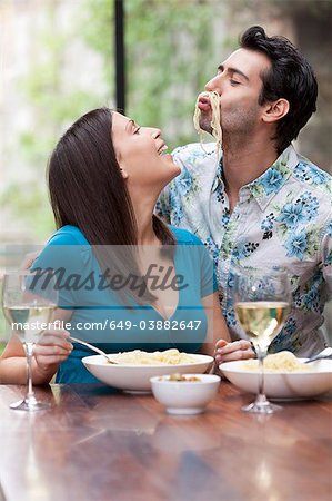 Couple ludique manger ensemble à table