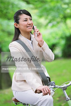 Businesswoman Using Mobile Phone while Bicycling