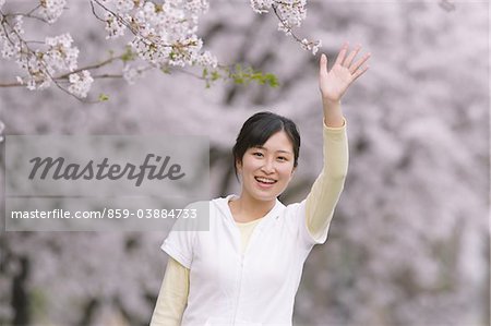 Teenage Girl Waving Under Cherry Blossom Tree