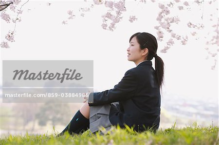 High School Girl Sitting Under Cherry Blossom Tree