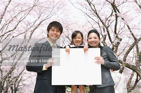 Eltern mit ihrer Tochter halten Whiteboard
