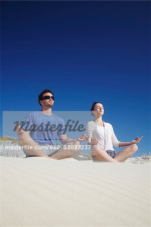 Jeune couple pratiquant d'yoga sur la plage, Perth, Australie-occidentale, Australie