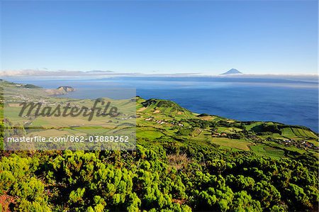 Volcanic craters along the Sao Jorge island and the Pico volcano on the horizon. Azores islands, Portugal