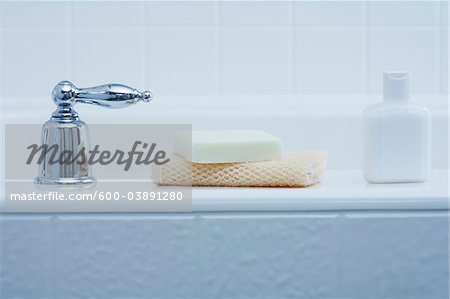 Badezusätze am Rand der Badewanne und Tap