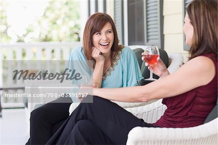 Zwei Frauen, die trinken Wein auf der Veranda