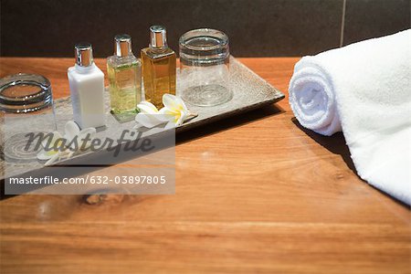 Perfume bottles and frangipani flowers on tray