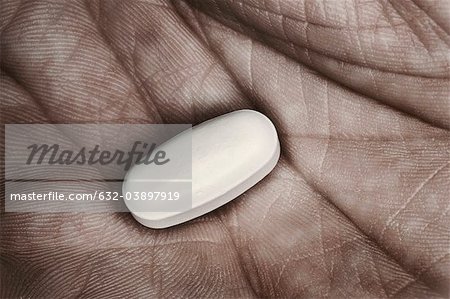 Einzelne Pille in des Mannes Hand, Nahaufnahme