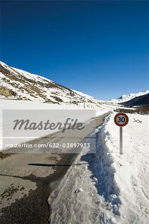 Speed limit sign on snow-covered road