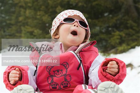 Fille de tout-petit s'amuser dans la neige