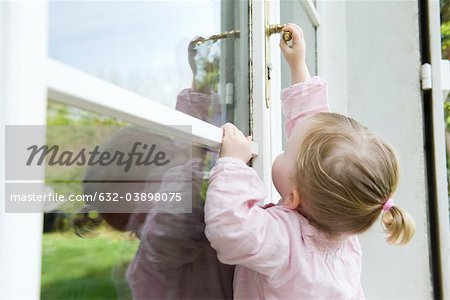 Toddler girl reaching to open door