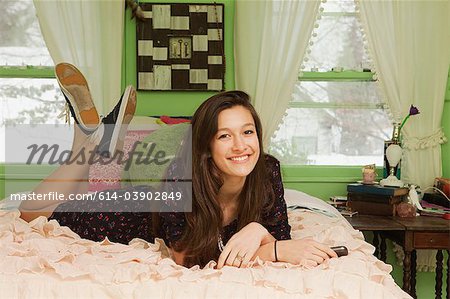 Teenage girl lying on bed, portrait