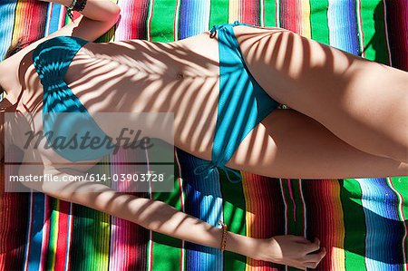 Woman lying on ethnic style blanket