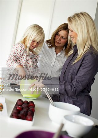 Zwei Frauen und ein Mädchen machen einen Kuchen, Schweden.